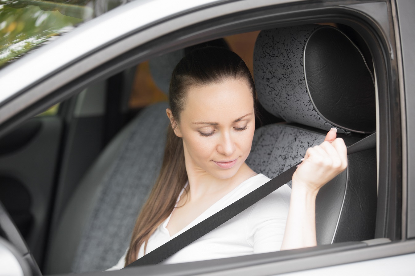 Close up of female hand fastening a safety belt for secure driving